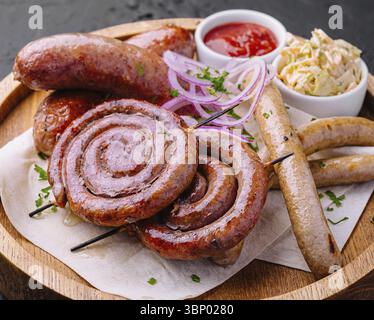 Gegrillte Würstchen auf einem Holzbrett mit Soße Stockfoto