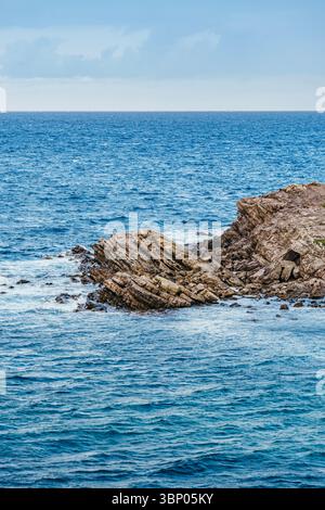 Zerklüftete menorquinische Küste mit dramatischen Felsformationen, tiefblauem Mittelmeer, Reisebroschüren und Umweltbelangen Stockfoto