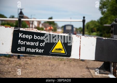 Nahaufnahme eines Warnschilds an einem Schleusentor mit der Aufschrift „Keep Boat Forward of Cill Marker“ (Boot vor Cill Marker halten), das wichtige Sicherheitshinweise für die Binnenwasserstraße u hervorhebt Stockfoto