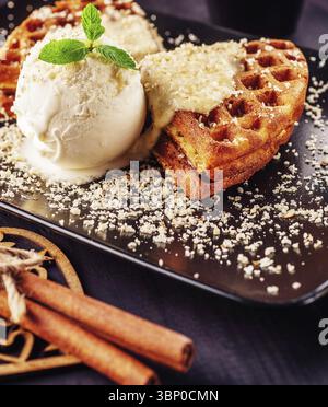 Essen Stillleben, Eis mit belgischen Waffeln, frische Minze, Vanilatoppen und Zimt Stockfoto