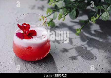 Stillleben von Lebensmitteln, Roter Cocktail, weißer Schaum, rote Blume Stockfoto