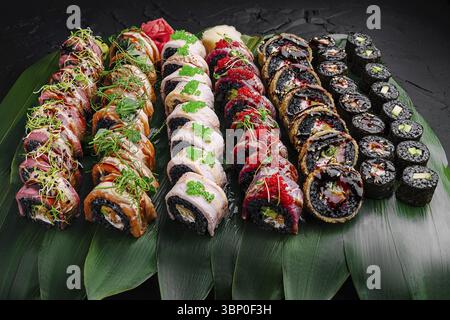 Food still-Life, Eine lebendige, wunderschön angeordnete Platte, zeigt eine Vielzahl von Sushi-Brötchen, die fachmännisch mit frischen Zutaten zubereitet und garniert werden Stockfoto