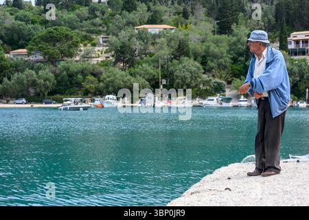 12-19/05/2025 Lakka, Paxos, Griechenland. Älterer Mann, der nur mit einer Schlange im Hafen angelt. Foto © Simon Grosset Stockfoto