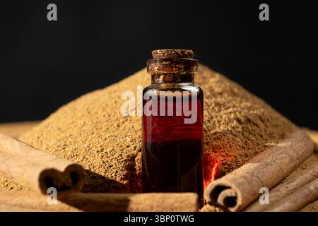 Natürliches ätherisches Zimtöl in einer Glasflaschennahmebildung Stockfoto