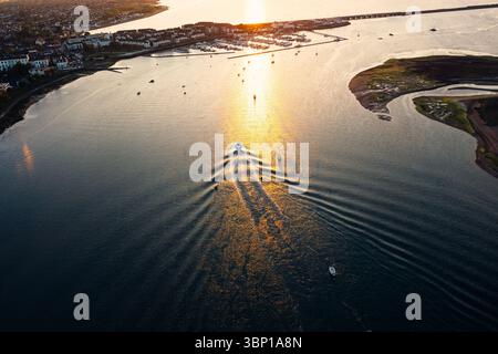 Blick von oben nach unten auf ein Boot, das zurück zum Dock in Malahide Marina geht, umgeben von anderen vertäuten Segelbooten Stockfoto