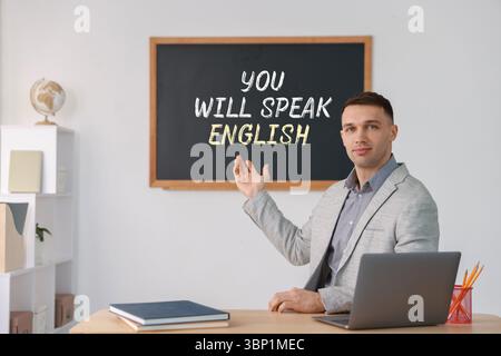 Lehrer, der auf Text zeigt, spricht Englisch auf schwarzem Tafel im Unterricht. Sprachkurs Stockfoto