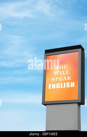 Sie sprechen englischen Text auf der Werbetafel vor blauem Himmel. Sprachkurs Stockfoto