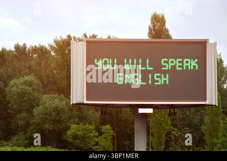Sie sprechen englische Texte auf digitalen Plakaten im Freien. Sprachkurs Stockfoto