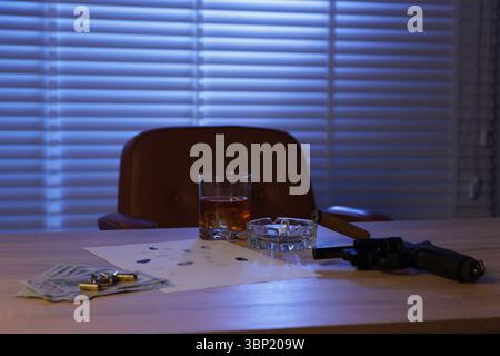 Mafia und kriminelle Welt. Pistole, Zigarre, Whiskey, Fingerabdrücke, Geld und Kugeln auf Holztisch drinnen Stockfoto