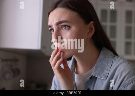 Besorgte Frau, die in der Küche an Paranoia leidet Stockfoto