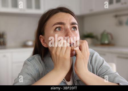Besorgte Frau, die in der Küche an Paranoia leidet Stockfoto