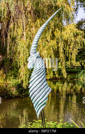 Eine stilisierte Metallskulptur einer Antilope mit einem spiralförmigen Horn, ausgestellt am See auf dem Gelände von Leeds Castle, Kent, Großbritannien Stockfoto