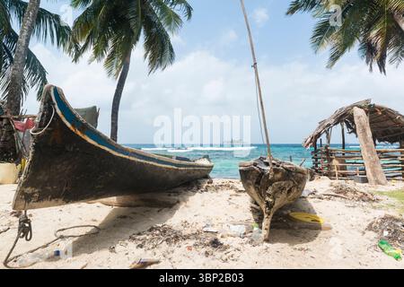 Zwei ausgegrabene Kanus am Strand einer Insel San Blas und Blick auf eine andere Insel in der Ferne. Schweinestall rechts. San Blas Archipel, Panama. Stockfoto