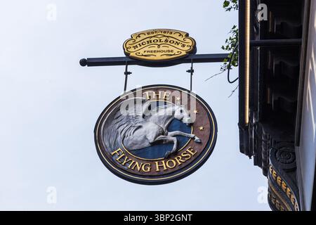 Englischer Pub-Schild „The Flying Horse“ mit weißem geflügelten Pferdeemblem. London, Vereinigtes Königreich, 11. Mai 2024 Stockfoto