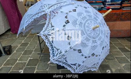 Zwei offene Sonnenschirme mit weißer Spitze auf dem Bürgersteig Stockfoto