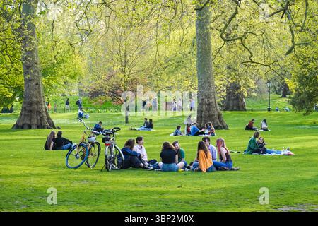 Junge Menschen genießen sonnigen Tag im St James's Park, London England Großbritannien Stockfoto