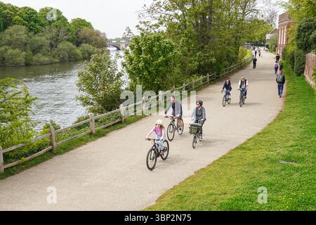 Menschen, die den sonnigen Frühlingstag auf dem Thames Path in Hampton, Richmond upon Thames, London, England, Großbritannien genießen Stockfoto
