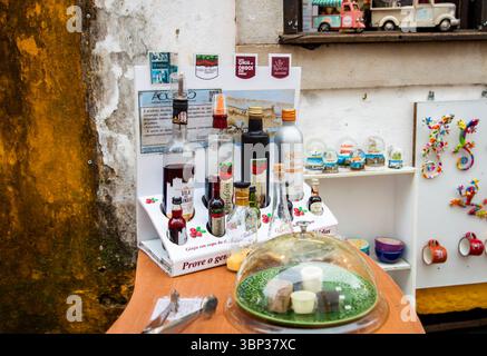 Obidos, Portugal, 8. März 2025. Blick auf farbenfrohe Flaschen und Schokoladentassen für die berühmte „Ginja de Óbidos“ oder „Ginjinha“, den Kirschlikör im h Stockfoto