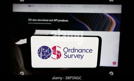 Deutschland. Juni 2025. In dieser Abbildung hält eine Person ein Handy mit dem Logo der britischen Kartenagentur Ordnance Survey (OS) auf dem Bildschirm vor der Webseite. Quelle: SOPA Images Limited/Alamy Live News Stockfoto