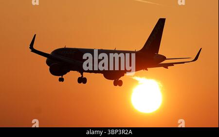 Dateifoto vom 02/25 eines EasyJet-Flugzeugs, das am Flughafen London Gatwick landet, während die Sonne über Crawley, West Sussex, aufgeht. Wenn man im Ausland auf Bargeld verzichtet, könnte dies laut Forschungen für manche Urlauber ein teurer Fehler sein, da mehr als jeder dritte sich bei der Notwendigkeit von physischem Geld entlarvt hat. Ausgabedatum: Sonntag, 6. Juli 2025. Stockfoto
