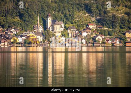 Sommer Österreich. Die Sonne erleuchtet das kleine Städtchen Hallstatt am See. Ein Spiegel aus ruhigem Wasser Stockfoto