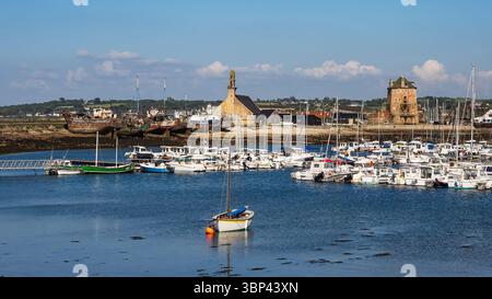 Blick auf den Hafen in Camaret-sur-Mer, Bretagne, Frankreich, mit dem Vauban-Turm, der Steinkapelle und dem historischen Bootsfriedhof unter einem sonnigen blauen Himmel. Stockfoto