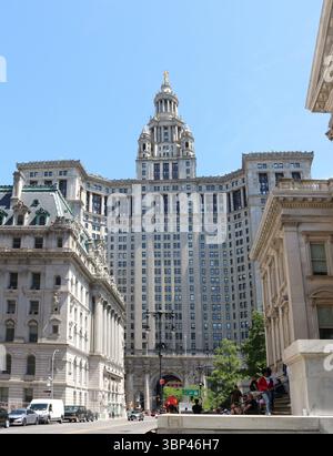 Ein Farbfoto des imposanten Manhattan Municipal Building, ein architektonisches Wahrzeichen der Beaux-Arts in New York City, vor einem klaren blauen Himmel, fertiggestellt 1914. Das David N. Dinkins Municipal Building, New York City, USA, gehört zu den größten Regierungsgebäuden der Welt und beherbergt über 2.000 Mitarbeiter von einem Dutzend Kommunalbehörden auf fast einer Million Quadratmeter Bürofläche. Das Gebäude beherbergt die Büros von drei gewählten Beamten? Der City Comptroller, der Staatsanwalt und der Präsident des Manhattan Borough? Und ist das Hauptquartier des städtischen Admini Stockfoto