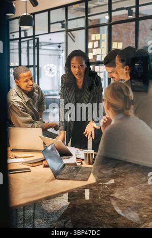 Geschäftsfrau bespricht Strategien mit dem Team im Büro Stockfoto