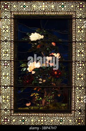 Ein Foto einer Buntglasscheibe von John La Farge mit dem Titel „Pfingstrosen im Wind blasen. Tiffany Glass bezieht sich auf die vielen und vielfältigen Glasarten, die von 1878 bis 1929?1930 in den Tiffany Studios in New York City von Louis Comfort Tiffany und einem Team von anderen Designern entwickelt und hergestellt wurden, darunter Clara Driscoll, Agnes F. Northrop und Frederick Wilson. Stockfoto