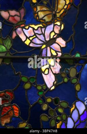 Ein Foto eines Details aus „Schmetterlinge und Laub“, einem Buntglasfenster von John La Farge. Tiffany Glass bezieht sich auf die vielen und vielfältigen Glasarten, die von 1878 bis 1929?1930 in den Tiffany Studios in New York City von Louis Comfort Tiffany und einem Team von anderen Designern entwickelt und hergestellt wurden, darunter Clara Driscoll, Agnes F. Northrop und Frederick Wilson. Stockfoto