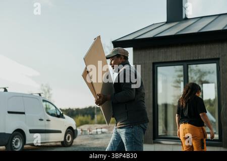 Senior Mann mit Holzdielen vor dem Haus Stockfoto