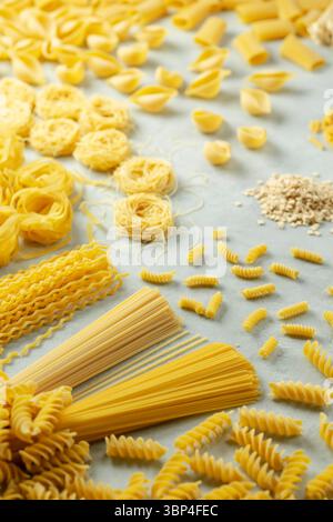 Verschiedene Nudelformen, die ordentlich auf einer hellen Oberfläche angeordnet sind Stockfoto