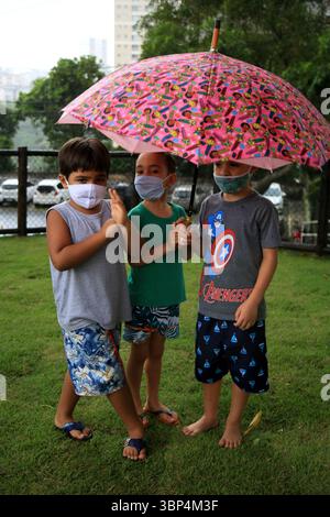 Kind mit Maske während covid-19 salvador, bahia, brasilien - 15. Mai 2021: Kinder unter einem Regenschirm in einem Park in der Stadt Salvador geschützt. SALVADOR BAHIA BRASILIEN Copyright: XJoaxSouzax 150521JOA560 Stockfoto