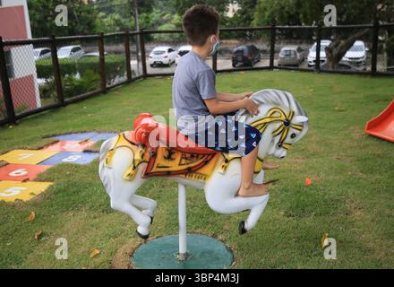 Kind, das während der covid-19-Periode eine Maske trägt salvador, bahia, brasilien - 15. Mai 2021: Kinder, die Masken tragen, werden während der covid-19-Zeit in der Stadt Salvador beim Spielen in einem Park gesehen. SALVADOR BAHIA BRASILIEN Copyright: XJoaxSouzax 150521JOA551 Stockfoto