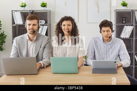 Porträt der Callcenter-Agenten im Headset, die mit einem Laptop arbeiten und mit Kunden kommunizieren Stockfoto