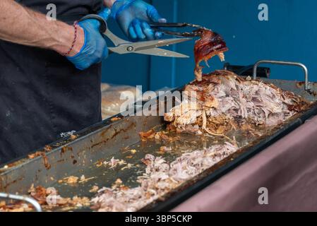 Schweinebraten werden zerschnitten und auf einem Food Festival zubereitet. Stockfoto