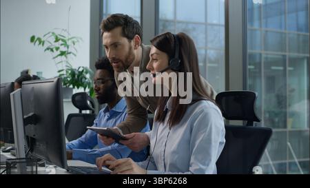 Call-Center-Inspektion multiethnische Betreiber arbeiten Online-Beratung Helpline Kundensupport im Büro Kaukasischer Chef überprüft Geschäftsarbeit Stockfoto