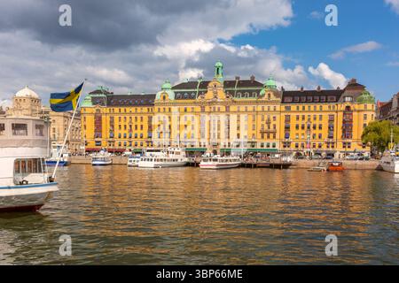 Boote liegen am Strandvagen mit historischem Gebäude in Stockholm, Schweden Stockfoto