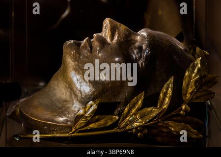 Eine bronzene Totenmaske Napoleons III., die mit einem goldenen Lorbeerkranz verziert ist, ist auf Schloss Arenenberg in Salenstein, Thurgau, Schweiz zu sehen. Es erinnert an den verstorbenen Kaiser und seine Zeit an diesem historischen Ort Stockfoto