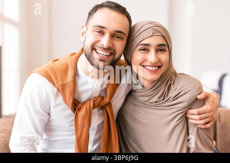 Happy Muslim Paar Umarmt Sitzen Zusammen Auf Der Couch Zu Hause Stockfoto