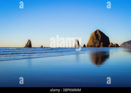 Haystack Rocks, Cannon Beach, Oregon - 27. November 2015: Die Menschen genießen den Strand und den Blick auf den berühmten Haystack Rock und andere Meeresstrände Stockfoto