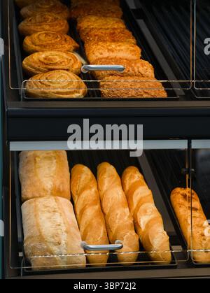 Frisch gebackenes Gebäck und Brot erwarten Sie in einer gemütlichen Bäckerei, die mit ihrem warmen Aroma und den goldenen Krusten alle vorbeiziehenden Besucher verführt Stockfoto