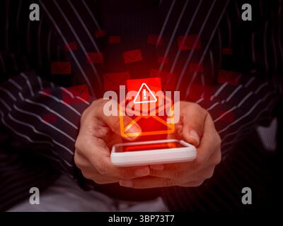 Warnungskonzept für SMS-Betrug. Rot geöffnetes Umschlagsymbol mit Warnschild als E-Mail-Hack oder Spam-Text, Malware breitet sich aus, während Geschäftsleute mobile p Stockfoto