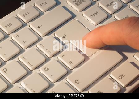 Drücken Sie die Eingabetaste mit dem Finger Stockfoto