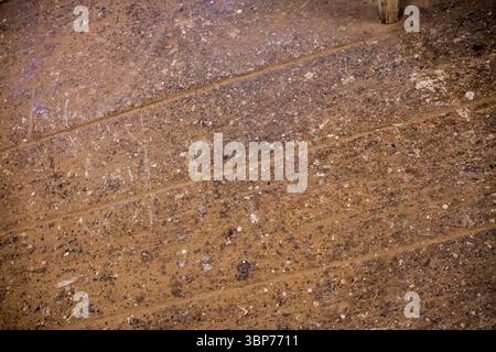 Abgenutzter Holzboden zeigt Farbspritzer, Staub, Ablagerungen mit Holzpfosten in der flachen Werkstattszene Stockfoto