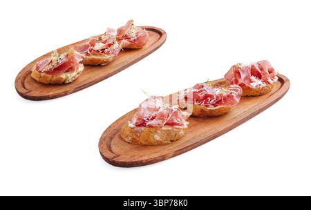 Essen, herzhafte kleine Happen von gepökeltem Schinken werden auf zwei Holzbrettern serviert. Die Präsentation hebt die Textur und die Aromen des Schinkens hervor und macht so einen Perfec Stockfoto