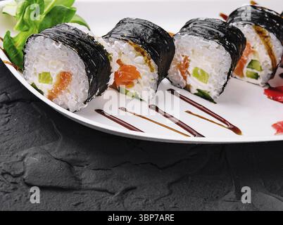 Essen, Nori-Sushi-Brötchen mit Lachs auf Teller Stockfoto