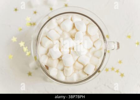 Blick von oben auf eine Tasse heißen, köstlichen Kakaogetränk mit Marshmallows auf goldenen Sternen Hintergrund Stockfoto