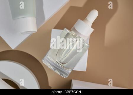 Transparente Kosmetikflasche mit Pipette auf weißem Podium, Produktverpackung, Anti-Aging-Serum mit Peptiden, Kosmetikmodell, Spa-Konzept Stockfoto