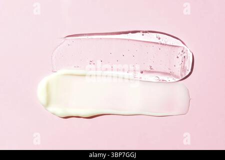 Weiße Creme und transparente Geltextur auf rosa Hintergrund. Ausstriche von Hautpflegemitteln Stockfoto